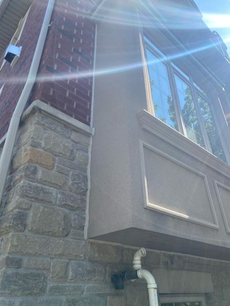 After: Bay window corner — stone-to-frame transition