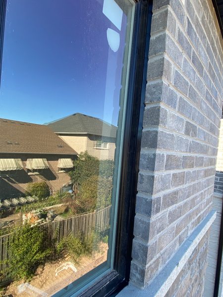 Black frame on grey brick — colour-matched perimeter bead