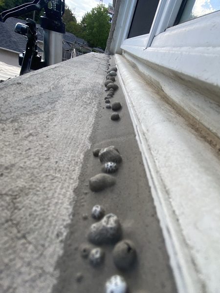 What happens when old caulking is not cleaned off properly — the new bead lets go and leaves lumps behind