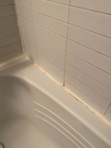 Before: Shower corner: old silicone removed, clean tooled joint