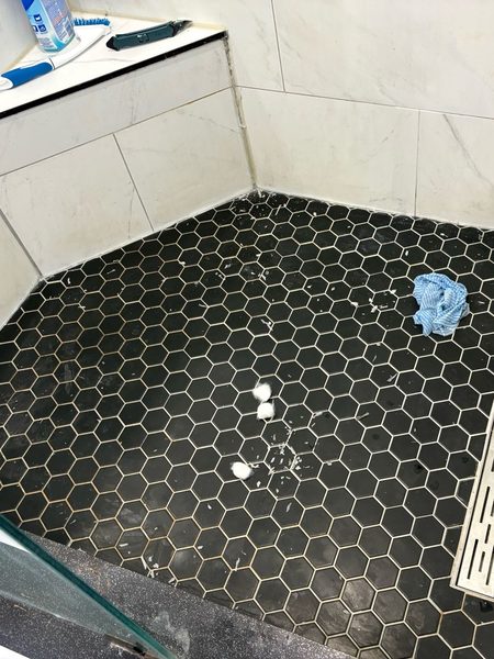 Before: Shower floor and bench: the floor-to-wall silicone stripped, sanitized and resealed