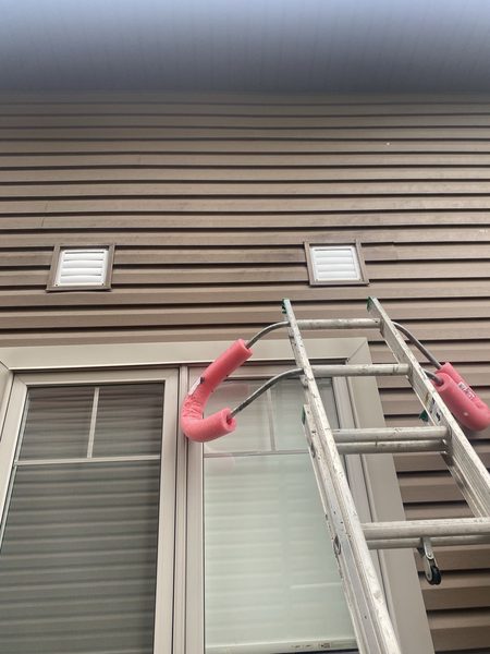 After: Exhaust vent covers on siding — cracked covers replaced, flanges resealed
