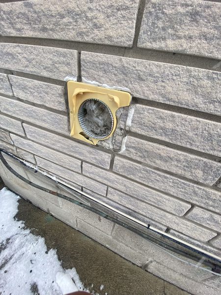 Before: Open duct on stone — a new hood fitted and the flange sealed